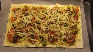 Blätterteig-Pizza mit Tomate Käse Oliven und Zwiebel (ungebacken)